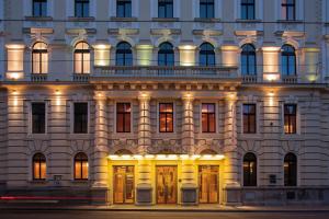 a large white building with lights on it at Austria Trend Hotel Savoyen Vienna - 4 stars superior in Vienna