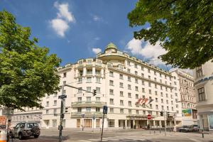 a large white building on the corner of a street at Austria Trend Hotel Ananas Wien in Vienna