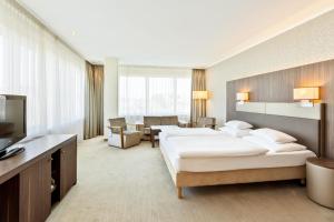 リンツにあるHotel Schillerpark Linz, a member of Radisson Individualsのベッド2台とテレビが備わるホテルルームです。