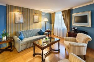a living room with a couch and a table at Austria Trend Hotel Ananas Wien in Vienna