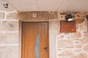 una puerta en un edificio de piedra con una señal encima en Casa da Vovó Luisa, 
