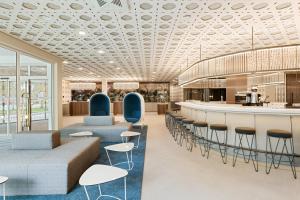 a lobby with a bar with blue chairs and tables at Austria Trend Hotel Bosei Wien in Vienna