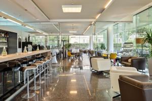 a lobby with a bar with chairs and tables at Austria Trend Hotel Congress Innsbruck in Innsbruck