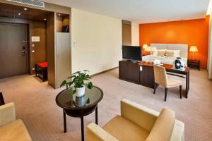 ウィーンにあるAustria Trend Hotel Savoyen Vienna - 4 stars superiorのベッド、ソファ、テーブルが備わるホテルルームです。