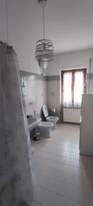 uma casa de banho com 2 WC e uma cortina de chuveiro em Alloggio turistico Matteo Simoncini em Montefiascone