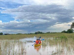 dos personas están en un kayak en un río en Mechrey Tonle Camp Site, en Siem Reap