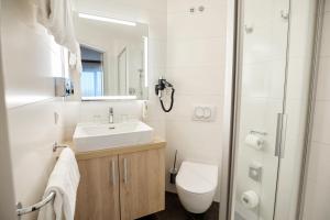 y baño con lavabo, aseo y ducha. en Austria Trend Hotel Salzburg Messe, en Salzburgo