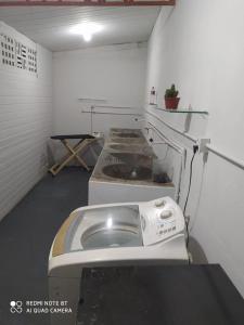 a room with a washing machine in a room at Acomodações no Jardim Tropical em Rondonópolis in Rondonópolis