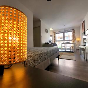 - une chambre avec un lit et une grande lumière orange dans l'établissement Le REVOL, à Grenoble