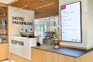 einen großen Bildschirm in der Hotellobby mit einem Maximillian in der Unterkunft Austria Trend Hotel Maximilian in Wien