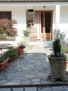 une passerelle en pierre devant une maison ornée de plantes dans l'établissement La casetta di Pio, à Fresonara