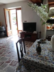 un salon avec une table et une télévision dans l'établissement La casetta di Pio, à Fresonara