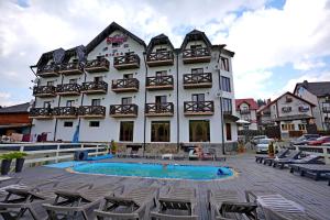 a large building with a swimming pool in front of it at Villa Loiza in Bukovel