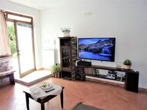 - un salon avec une télévision à écran plat dans un centre de divertissement dans l'établissement Villa Sole e Mare, à Vallo della Lucania