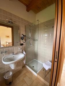 La salle de bains est pourvue d'un lavabo et d'une douche. dans l'établissement La Casetta di Alessia - Agriturismo con camere, 