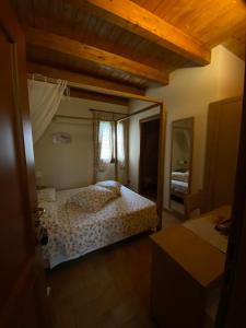 - une chambre avec un lit et un plafond en bois dans l'établissement La Casetta di Alessia - Agriturismo con camere, 