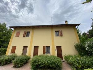 une maison jaune avec des fenêtres et un toit dans l'établissement La Casetta di Alessia - Agriturismo con camere, 