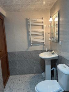 a bathroom with a white toilet and a sink at Guest House MIRA in Martvili +36 photos