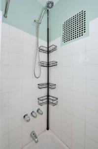 a shower in a white tiled bathroom with shelves at Cosy Studio Close to Times Square NYC in New York