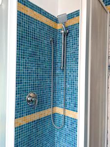 y baño con ducha y pared de azulejos azules. en The Boutique Houses Milan - Repubblica - Central Station, en Milán