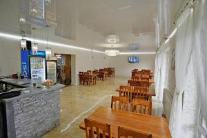 um restaurante com mesas e cadeiras de madeira e um bar em Villa Loiza em Bukovel