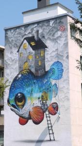 une peinture murale d'un poisson avec une maison sur elle dans l'établissement Le REVOL, à Grenoble