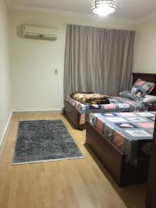 um quarto com duas camas e um tapete em Gaser resident em Cidade 6 de Outubro
