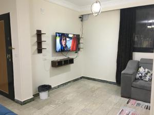 uma sala de estar com uma televisão na parede em Gaser resident em Cidade 6 de Outubro