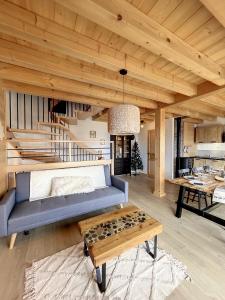 ein Wohnzimmer mit einem blauen Sofa und einem Tisch in der Unterkunft Chalet L'Arguille in La Toussuire