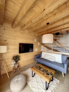 ein Wohnzimmer mit einem blauen Sofa und einem Tisch in der Unterkunft Chalet L'Arguille in La Toussuire