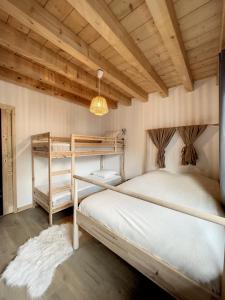 1 Schlafzimmer mit 2 Etagenbetten und einer Holzdecke in der Unterkunft Chalet L'Arguille in La Toussuire