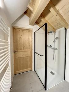 baño con ducha y puerta de cristal en Chalet L'Arguille en La Toussuire