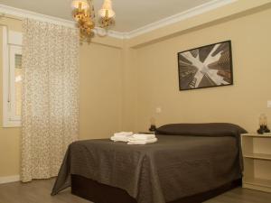 1 dormitorio con 1 cama con toallas en Apartamento Góngora en Sevilla