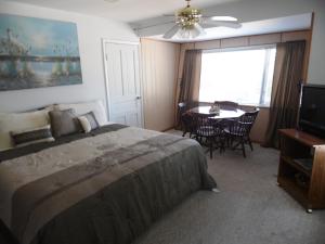 a bedroom with a bed and a table and a television at Sunset Inn in South Haven