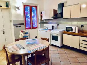 cocina con mesa y cocina con microondas en Teo Country House, en San Martino Siccomario