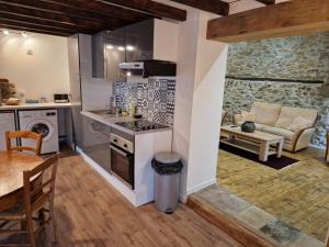 a kitchen and living room with a stove and a table at Le Grand Cerf - 4 Couchages in Nalzen