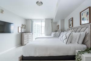 Habitación blanca con 2 camas y TV. en Limited time Deal 1BR 1BATH Located at ICON Brickell, en Miami 18 fotos más