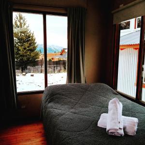 a bedroom with a bed and a window with snow at Tiny house Bariloche in San Carlos de Bariloche
