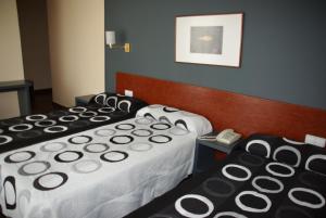 two beds in a hotel room with a phone at Hotel Yerri in Estella