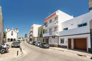 a street with cars parked on the side of the road at Privilege Casa dos Capuchinhos, in the heart of Faro in Faro