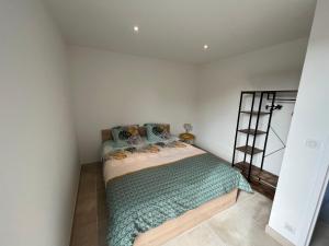 a bedroom with a bed with a green comforter at Balcon sur la rivière in Périgueux