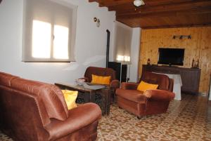 a living room with two chairs and a television at Casa La Pechá, Ronda (Málaga) in Ronda