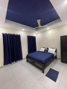 1 dormitorio con 1 cama con techo azul en Uniro Rooms & Packages, en Kochi