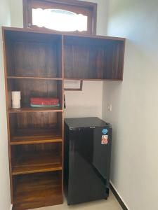 a room with a black refrigerator and a shelf at Ksf surf house in Uluwatu
