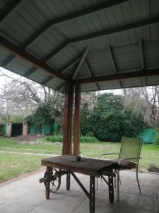 una mesa de picnic y una silla bajo un techo en Nomads Buenos Aires en Bella Vista