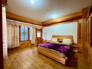 een slaapkamer met een groot bed en een groot raam bij One Light Stays - Kasol in Kasol