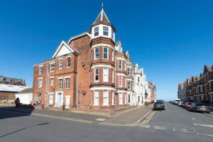 a large brick building with a clock tower on a street at No.18 - Ground Floor apartment close to the beach in Cromer
