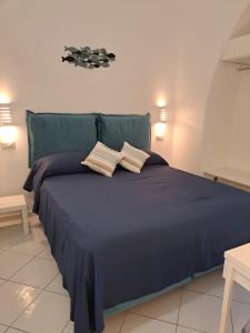 1 dormitorio con 1 cama azul y 2 almohadas en Tre Re Appartamento Matima, en Capri