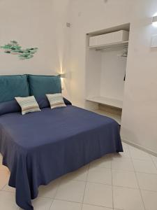 a bedroom with a blue bed with two pillows at Tre Re Appartamento Matima in Capri