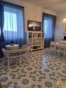 un salon avec une télévision, une table et des chaises dans l'établissement Tre Re Appartamento Matima, à Capri 8 autres photos